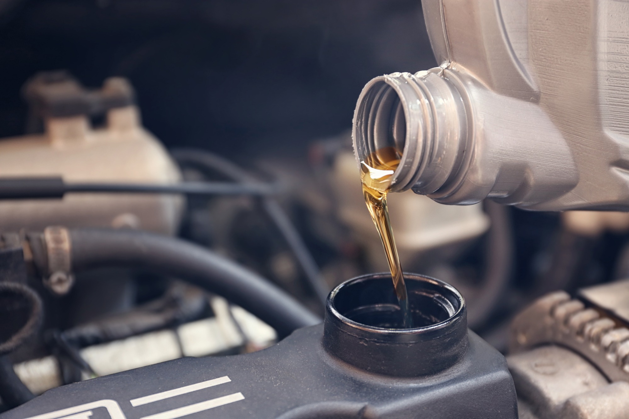 Pouring oil to car engine, close up